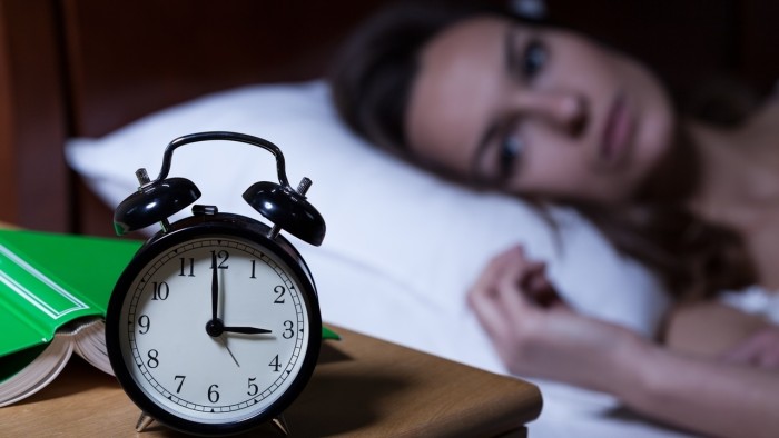 Alarm clock on night table showing 3 a.m.