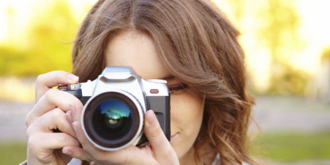 Young woman uses digital slr photocamera.