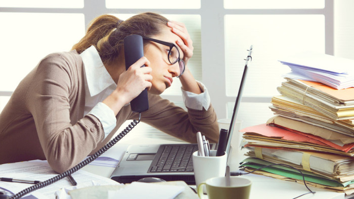 a-stressed-business-woman-looks-tired-she-answer-telephones-in-her-office